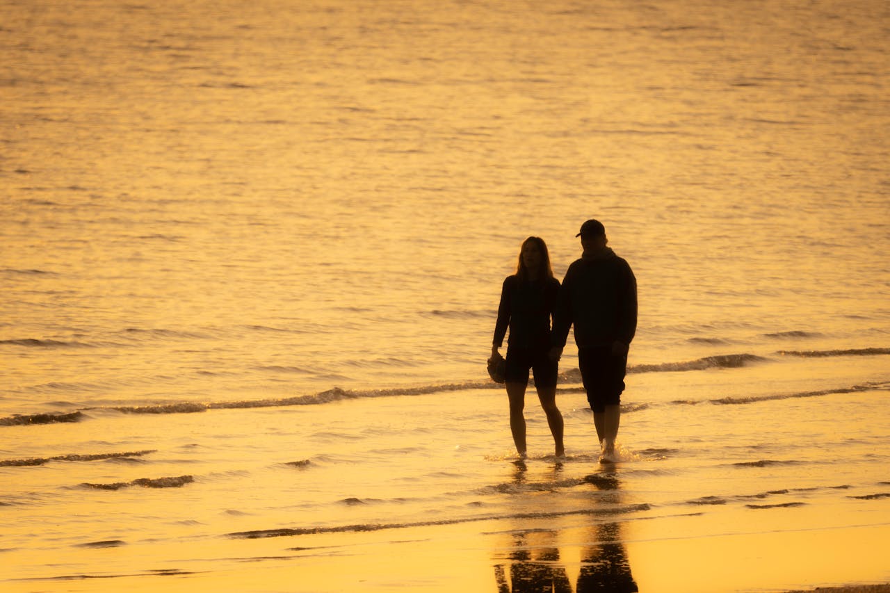 romantic-sunset-walk-along-the-beach-shore-32887206